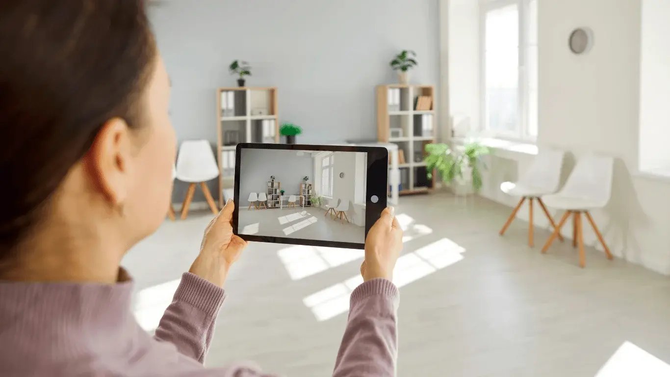 Mujer usando una tablet para registrar una habitación luminosa durante un proceso de postventa digital sin papel.